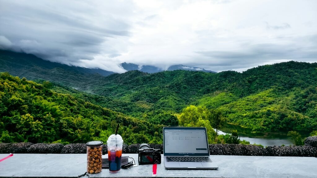 A minimalist workspace with a laptop, coffee, and mountain view representing stress-free habits in 2026.